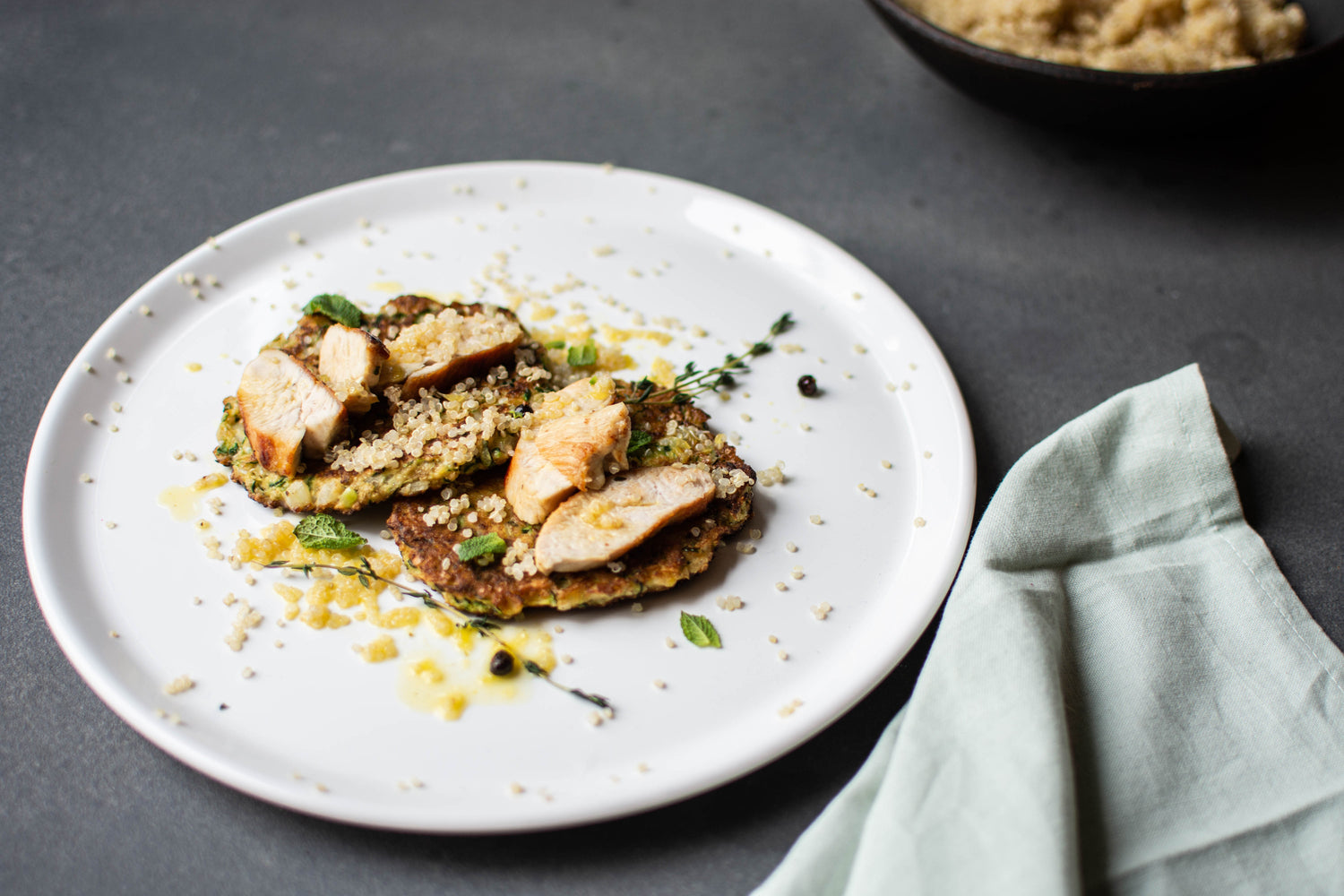 Kalkoenfilet met sinaasappelsaus, courgette-muntpannenkoekje en quinoa.