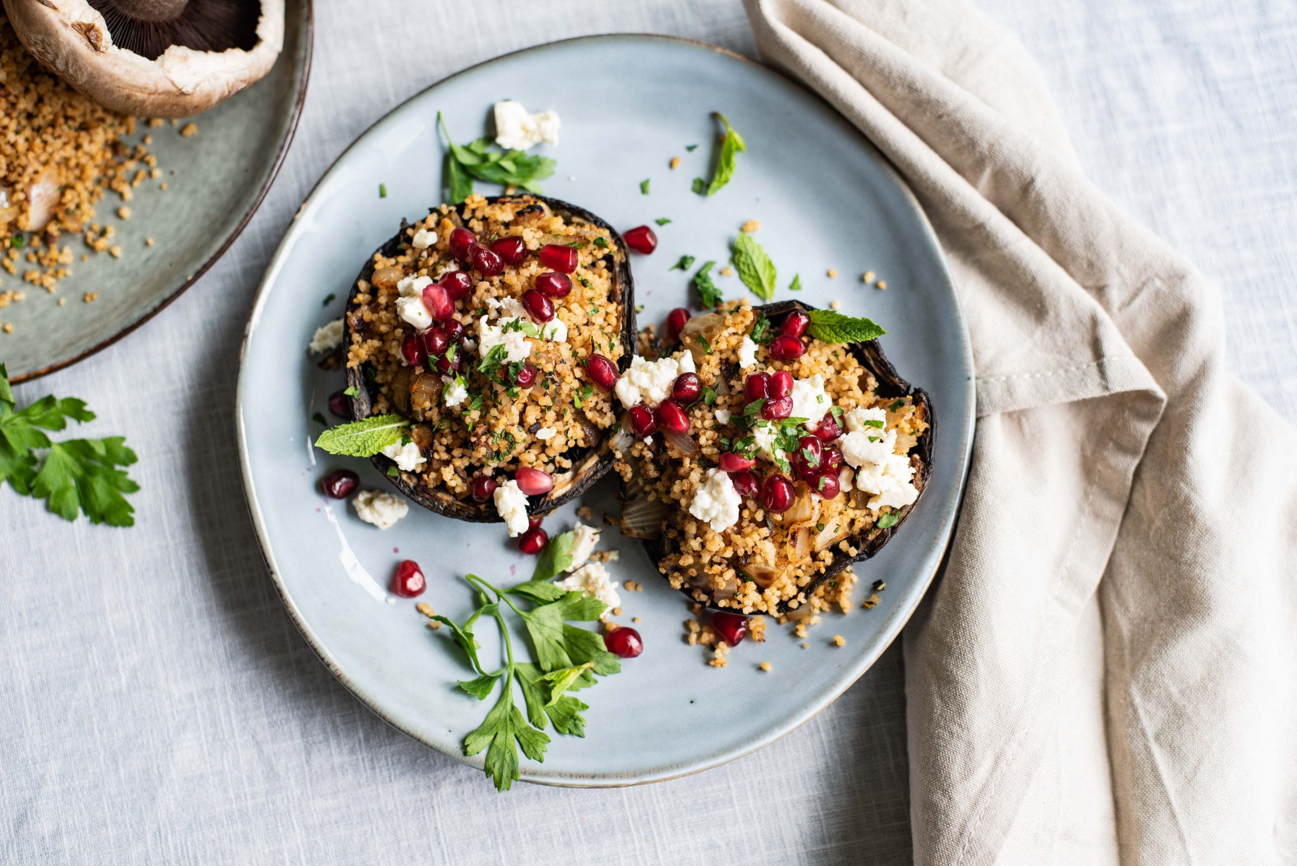 Portobello met groene-kruidencouscous, kaas en granaatappel